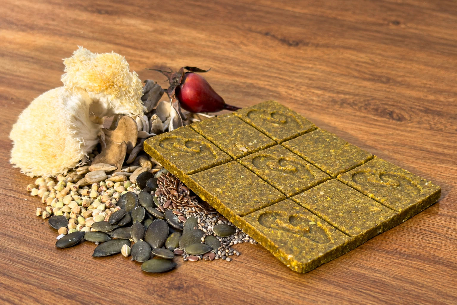 The nine-square topper with mushrooms, rosehip and seeds on a clear wooden tabletop.